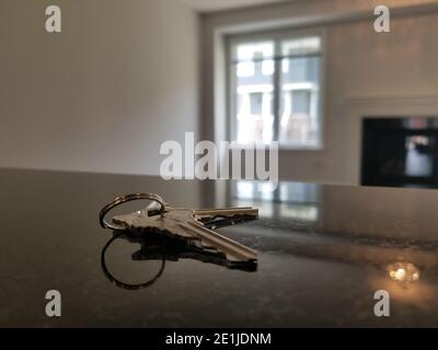 house keys on table top counter in empty house. Stock Photo