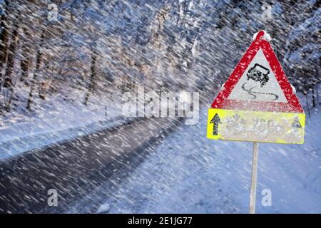 Strassenschild warnt vor Schneeglätte und Eis im Winter Stock Photo