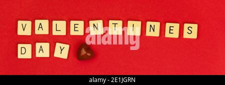 Valentine's Day banner on red background, letter and word on cubes and red heart, for blogger photo Stock Photo