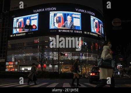 (210107) -- TOKYO, Jan. 7, 2021 (Xinhua) -- Japanese Prime Minister Yoshihide Suga speaking at a news conference is seen on screens in Tokyo, Japan, on Jan. 7, 2021. The prime minister declared a state of emergency in the Tokyo metropolitan area including Tokyo, Saitama, Chiba and Kanagawa prefectures on Thursday, authorizing tougher measures to fight a resurgence in COVID-19 infections. The state of emergency will be effective from Friday to Feb. 7, with measures including urging people to stay at home and calling for restaurants and bars to stop serving alcohol by 7 p.m. and close by 8 p.m. Stock Photo