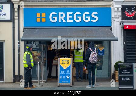 Slough, Berkshire, UK. 7th January, 2021. Construction workers queue for their lunch at Greggs. Slough was much quieter than usual today on day two of the new Covid-19 national lockdown. The number of positive Covid-19 cases in Slough is spiralling out of control. For the seven days up to 2 January 2021 the figures per 100,000 for Slough were 1064.6 up from 722.2. The average figure across England is only 606.9 for the same period. Credit: Maureen McLean/Alamy Live News Stock Photo