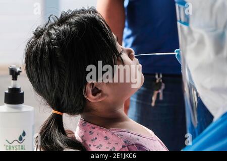 Shah Alam, Malaysia. 07th Jan, 2021. A medical worker wearing a personal protective equipment (PPE) takes a nasal swab sample from a child during the Covid-19 screening test in Shah Alam. Malaysia has recorded 3,027 new cases of coronavirus today bringing the total to 128, 465 cases. Selangor has conducted targeted community screening on residents around Sri Muda, Shah Alam following a spike of Covid-19 positive cases. Credit: SOPA Images Limited/Alamy Live News Stock Photo