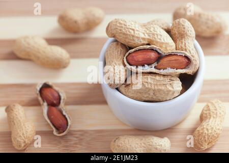 Peanuts in a small white bowl. Close up. Stock Photo