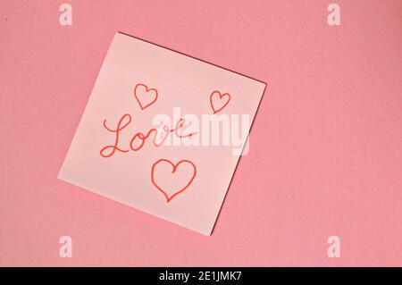 The word love written by hand and put on the pink table with copy text and hearts Stock Photo