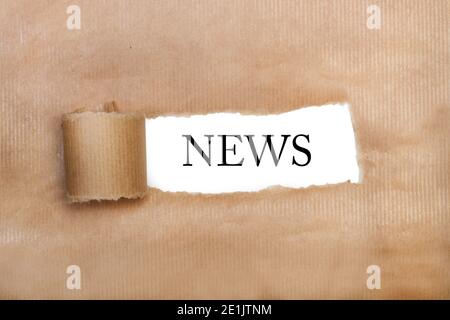 A tear brown paper with news word write in it Stock Photo