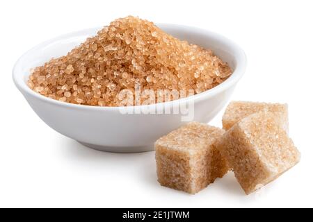 Light brown granulated sugar in white ceramic bowl next to light brown sugar cubes isolated on white. Stock Photo