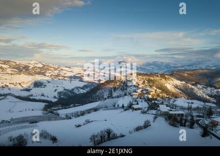 Aerial panoramic view of Ruino town in Oltrepo Pavese covered in snow during sunset in Lombardy Italy Stock Photo