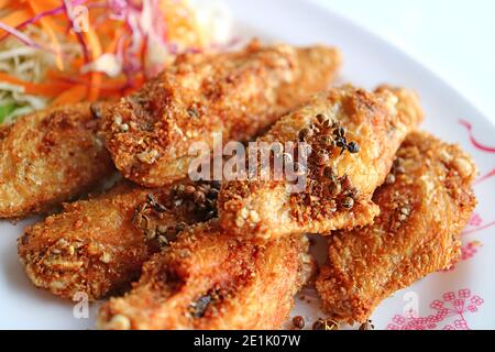 Closeup Thai Northern Style Deep Fried Chicken Wings with Hot and Spicy Herbs Stock Photo