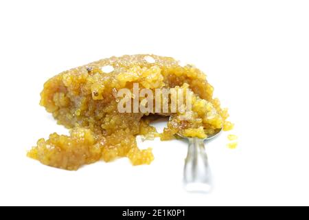 Silver spoon with sweet pongal on white backgrounds. Stock Photo