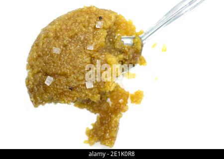 Silver spoon with sweet pongal on white background. Stock Photo