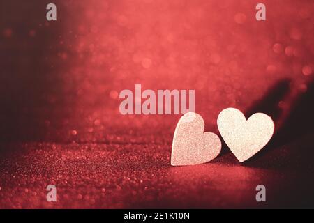 Two golden hearts on a red background with glitter Stock Photo