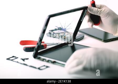 A technician repairs a broken tablet Stock Photo