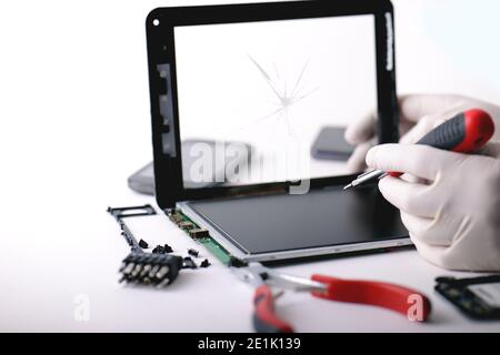 A technician repairs a broken tablet Stock Photo