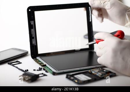A technician repairs a broken tablet Stock Photo