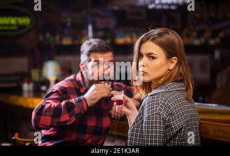 Young woman has problems with alcohol. Female male alcoholism. Woman and man alcoholism. Young man drinking alcohol. Woman alcoholic beverage in bar Stock Photo