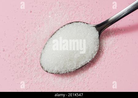 Spoon of Sugar on pink background Stock Photo