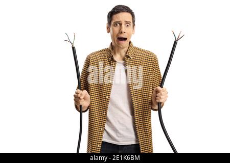 Shocked young man holding a broken elecrtic cable and looking at camera isolated on white background Stock Photo