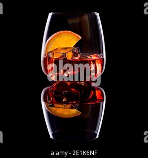 Negroni aperitif with ice cubes and slice of orange in glass on black background. Stock Photo