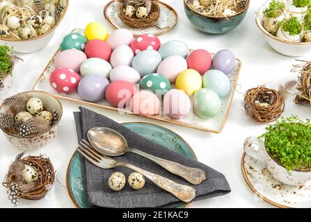 Festive table place setting. Easter decoration colored eggs Stock Photo