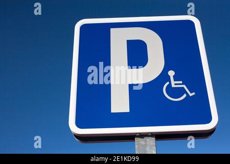 Signal that indicate priority parking for vehicles of people with disabilities. Blue sky background Stock Photo