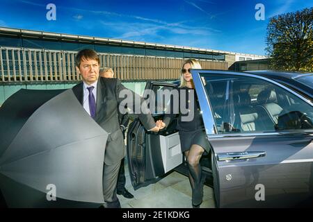 Chauffeur Opening Private Car Door For Businesswoman Stock Photo