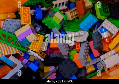 Ottawa, Ontario, Canada - January 7, 2021: An orange bin contains bricks and other pieces from LEGO building toys. Stock Photo