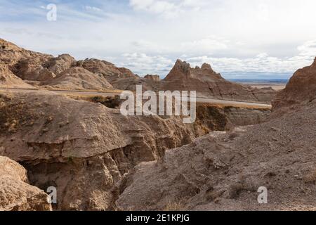 Road through rugged terrain and eroded landscape in Badlands National Park, South Dakota Stock Photo