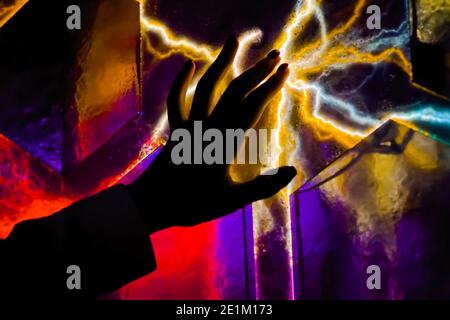 Woman hand touching plasma panel display in dark room of museum - close up view Stock Photo