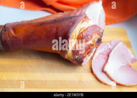 juicy smoked pork shank, delicious meat appetizer, sliced pieces on a wooden board, food,copy space Stock Photo