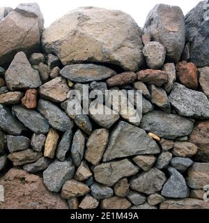 Stone wall built from various rocks in a rural setting showcasing natural textures and colors Stock Photo