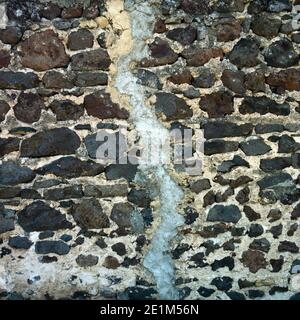 Cracked  wall. Unique textured stone wall displays the effects of time and weathering Stock Photo