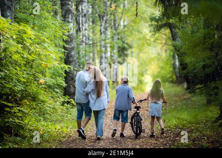 Rear view of family walking along autumn path in a park or forest Stock Photo
