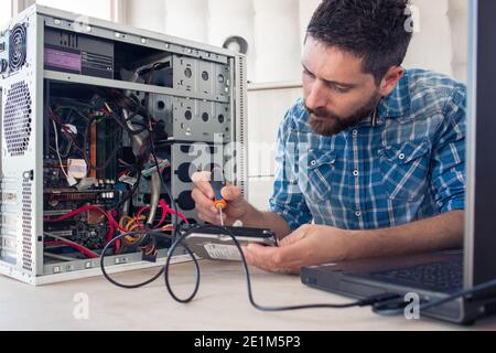 Engineer repairs computer's hard drive Stock Photo