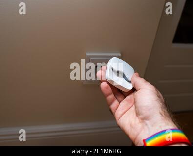 Male hand holding night light next to power outlet - ready to be plugged Stock Photo