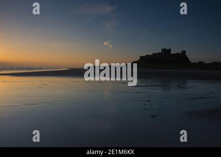 Sunrise at Bamburgh castle and beach Stock Photo