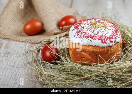 Festive Easter cake on a light background, decorated with multi-colored dragees. Painted Easter eggs as an attribute of Easter. Close-up. Studio light Stock Photo