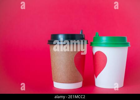 disposable paper cups with red heart on bright red background. Valentine's Day. Stock Photo