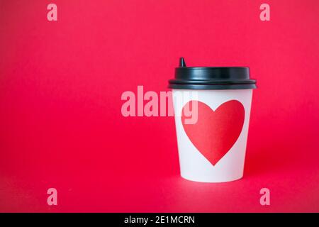 disposable paper cups with red heart on bright red background. Valentine's Day. Stock Photo