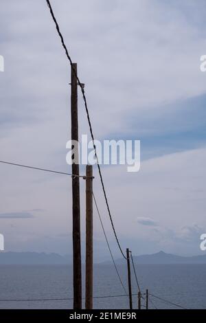 Telephone lines leading towards sea coastline, mediterranean, East Attica, Greece. Stock Photo