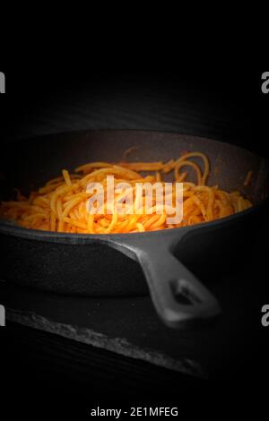 Spaghetti bolognese cooked in a cast iron frying pan.  With lighting effect Stock Photo