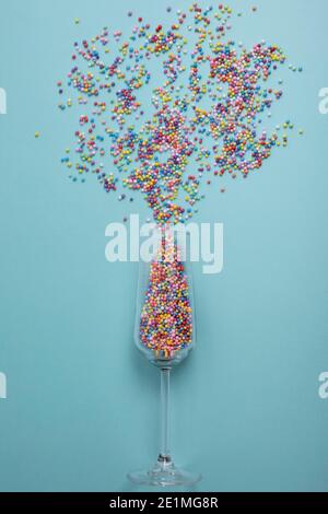colorful explotion from champagne glass with blue background. Simple concept Stock Photo