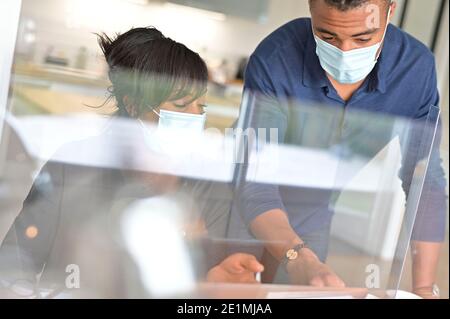 Start-up people working in co-working space office, wearing face mask during 19-ncov pandemic Stock Photo