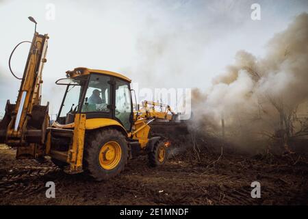 Excavator loaded with earth and carrying out a clearing in a work Stock Photo