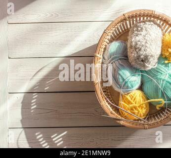 knitting yarn and needles in a basket. top view. blue, mint and yellow multicolored yarn. copy space for text. knitting as a hobby. Stock Photo