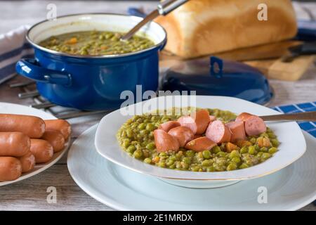 set kitchen table with fresh cooked pea soup and sausages Stock Photo