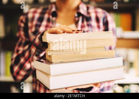 Close up of females hands holding books in front of the camera. Stock Photo