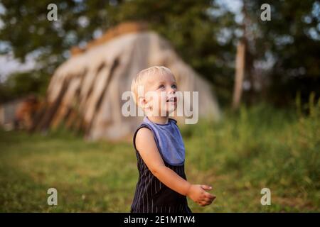 Cute little blue eye boy playing in a backyard on a summer day. Stock Photo