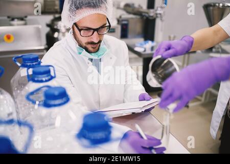 Cheerful lab employee taking notes of test experiments. Stock Photo