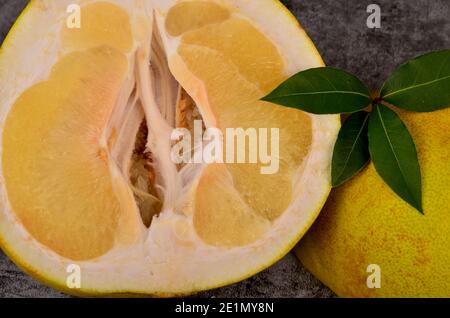 Cut in half the pomelo fruit on a dark background Stock Photo