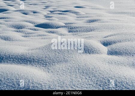 Gentle soft snowdrifts on frosty day. Winter landscape with snow covered field Stock Photo
